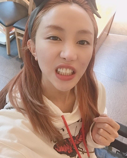 Cheon Sang Ji Hee is taking a selfie with a mischievous look