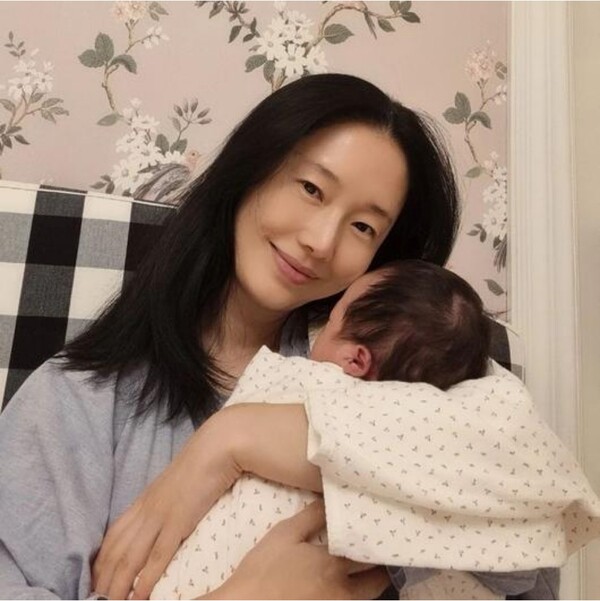 Lee Jeong-hyeon, smiling happily while holding her second daughter in her arms...