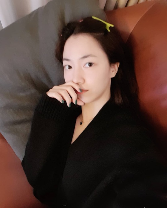 Ryu Hwa-young is taking a selfie while lying on the sofa