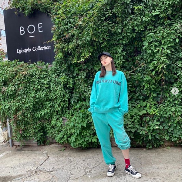 Lee Ju-yeon is posing in a green training suit