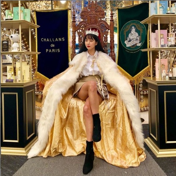 ‘조현영’ is wearing a golden gown and sits on the throne